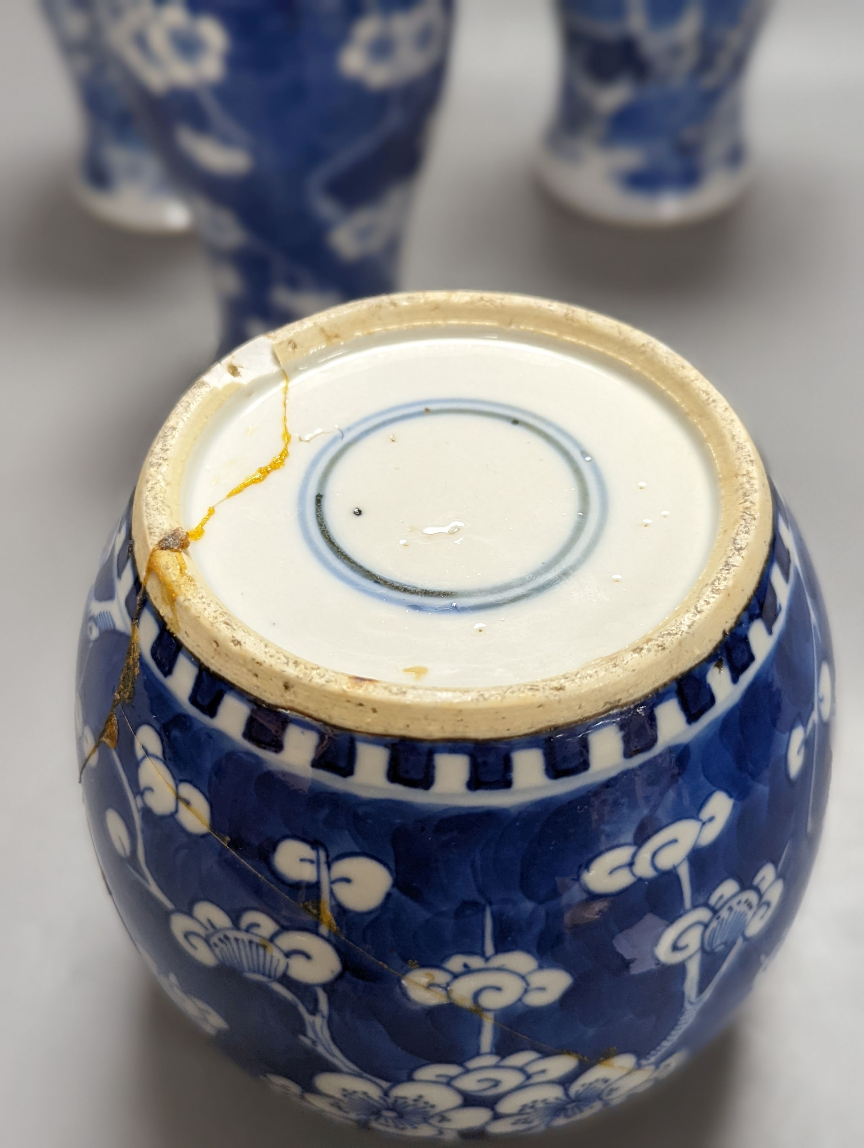A pair of 19th century Chinese blue and white vases, a prunus vase and cover and a similar jar (4), pair of vases 24 cms high.